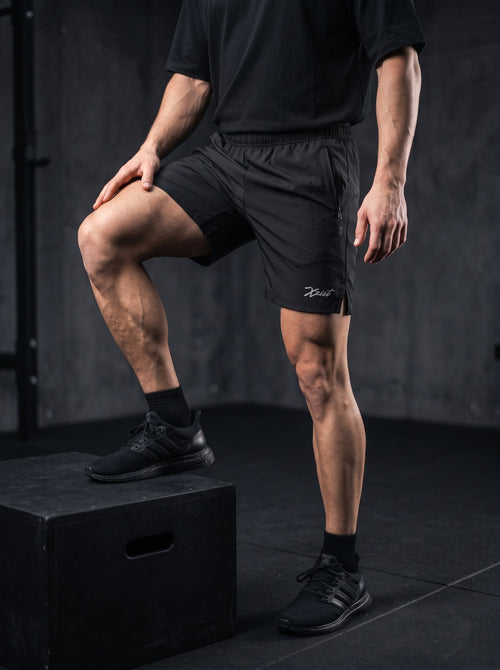 XZIZT gym shorts in black, model doing step-up exercise #Color_Black